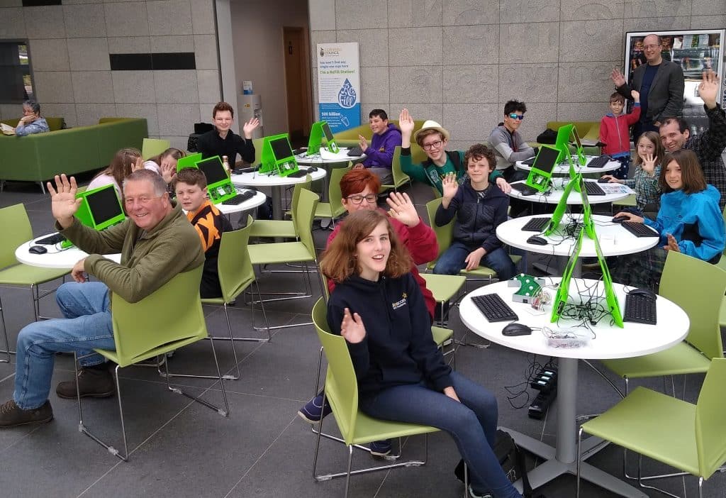 Tech Cornwall Tech Jam in Bodmin - children and adults sat at computers waving at the camera.